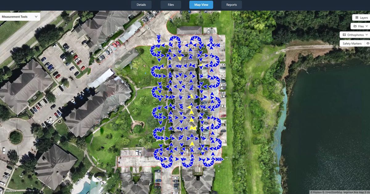 DataDelivery Map View showing an orthomosaic of an apartment complex with arrows marking where each drone photo was taken